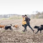 Julie Willems courant dans les champs avec les chiens